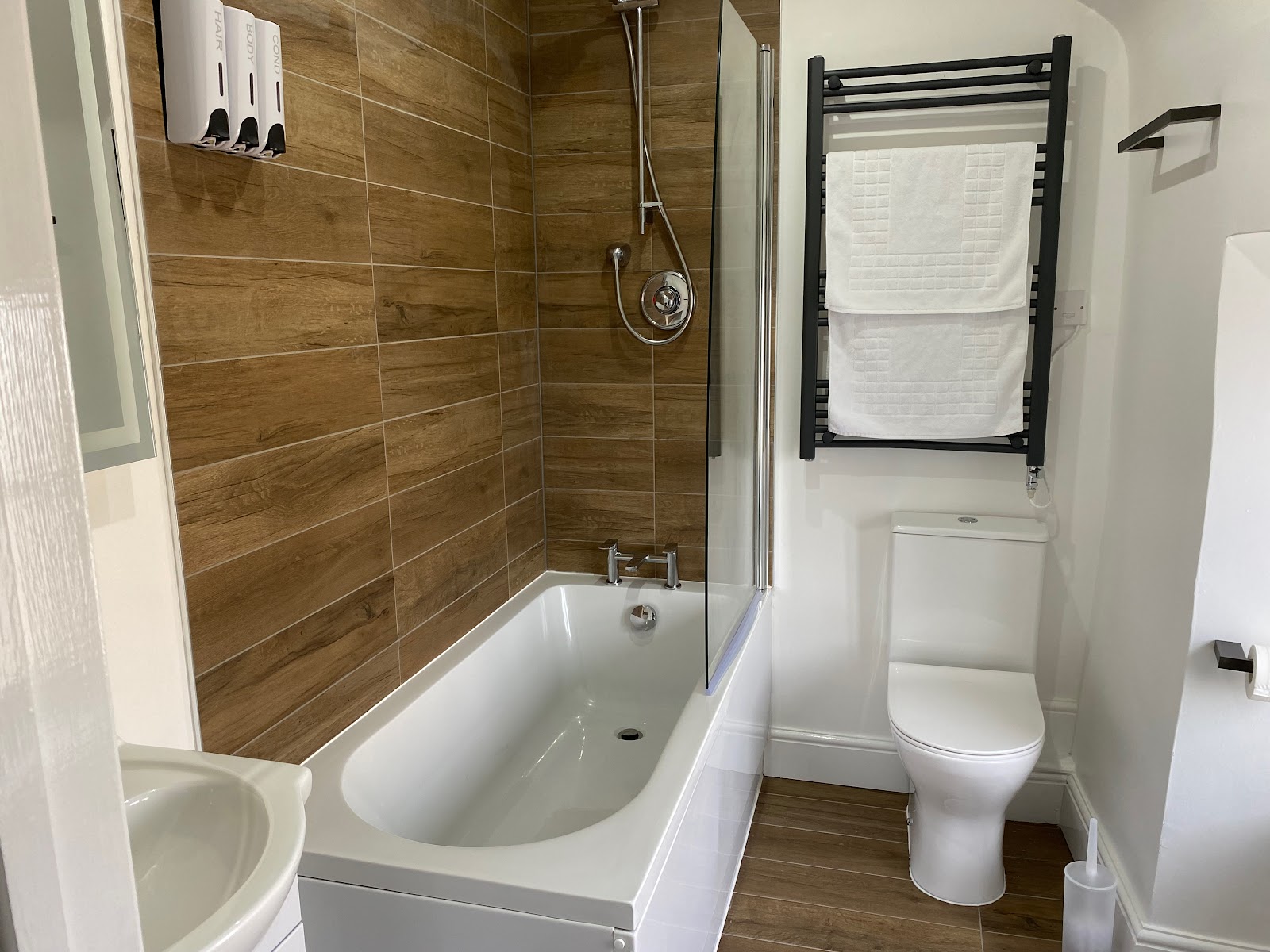Modern bathroom with bathtub, shower, and toilet at The Roade House in Roade.